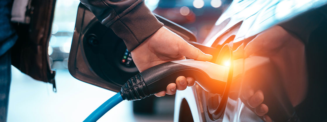 mano conectando cargador de vehículo eléctrico