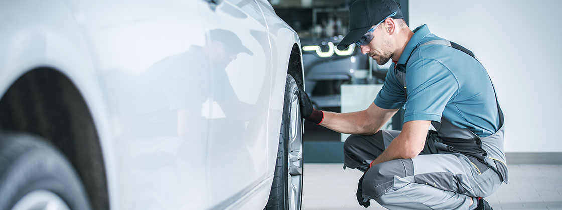 hombre a lado de llanta de coche revisando