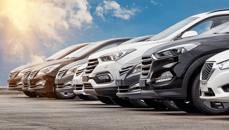 row of cars parked blue sky