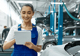 mujer en ipad en taller de coches