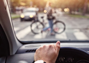 mano sobre volante esperando a que ciclista pase