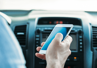 hombre manejando con celular en mano