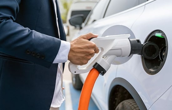 hombre enchufando cargador de EV