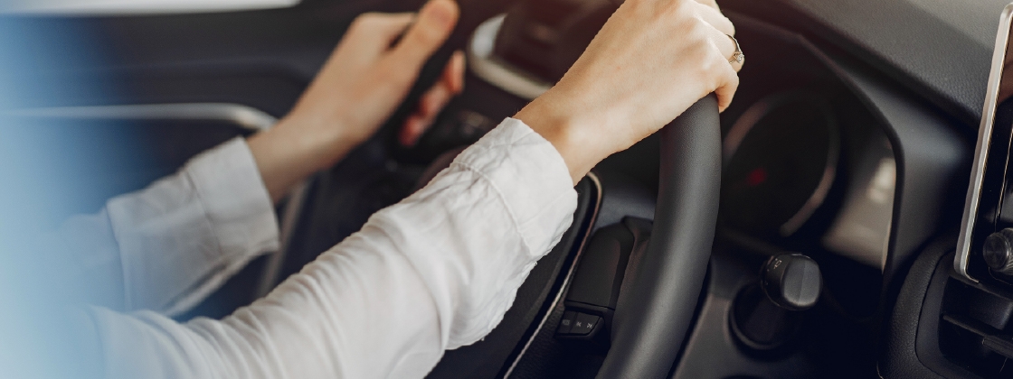 dos manos de mujer en volante de coche
